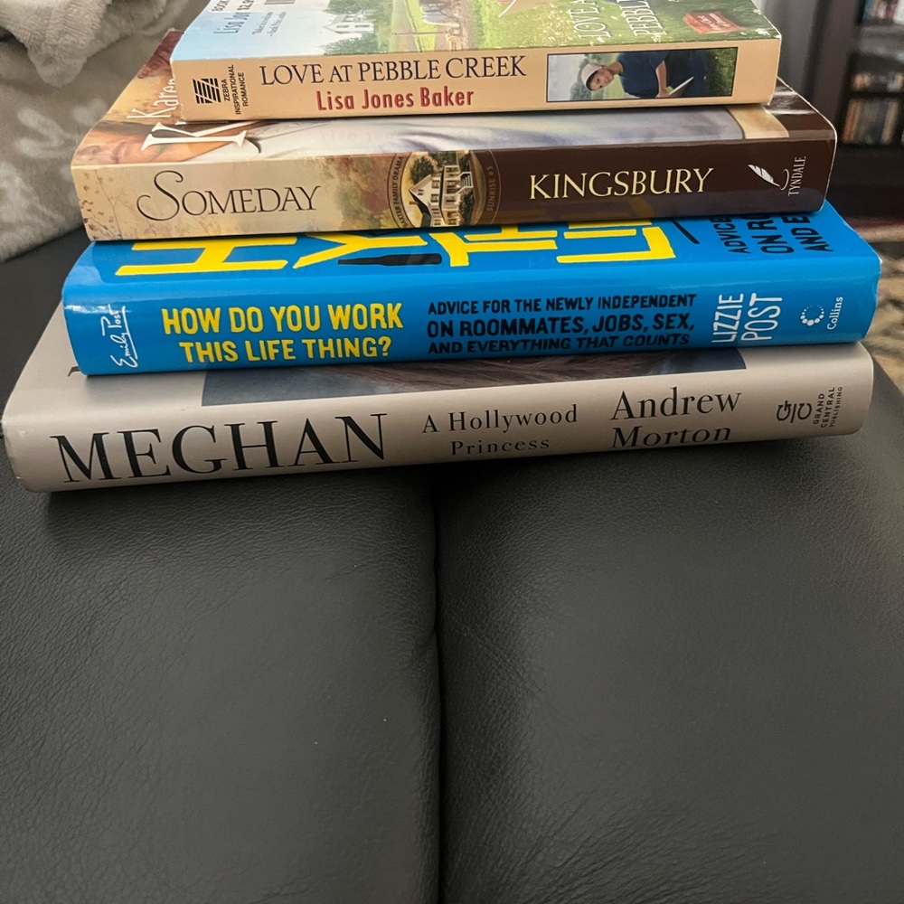 Stack of Assorted Books on Black Leather Surface - Blue, Gray, Brown, Yellow